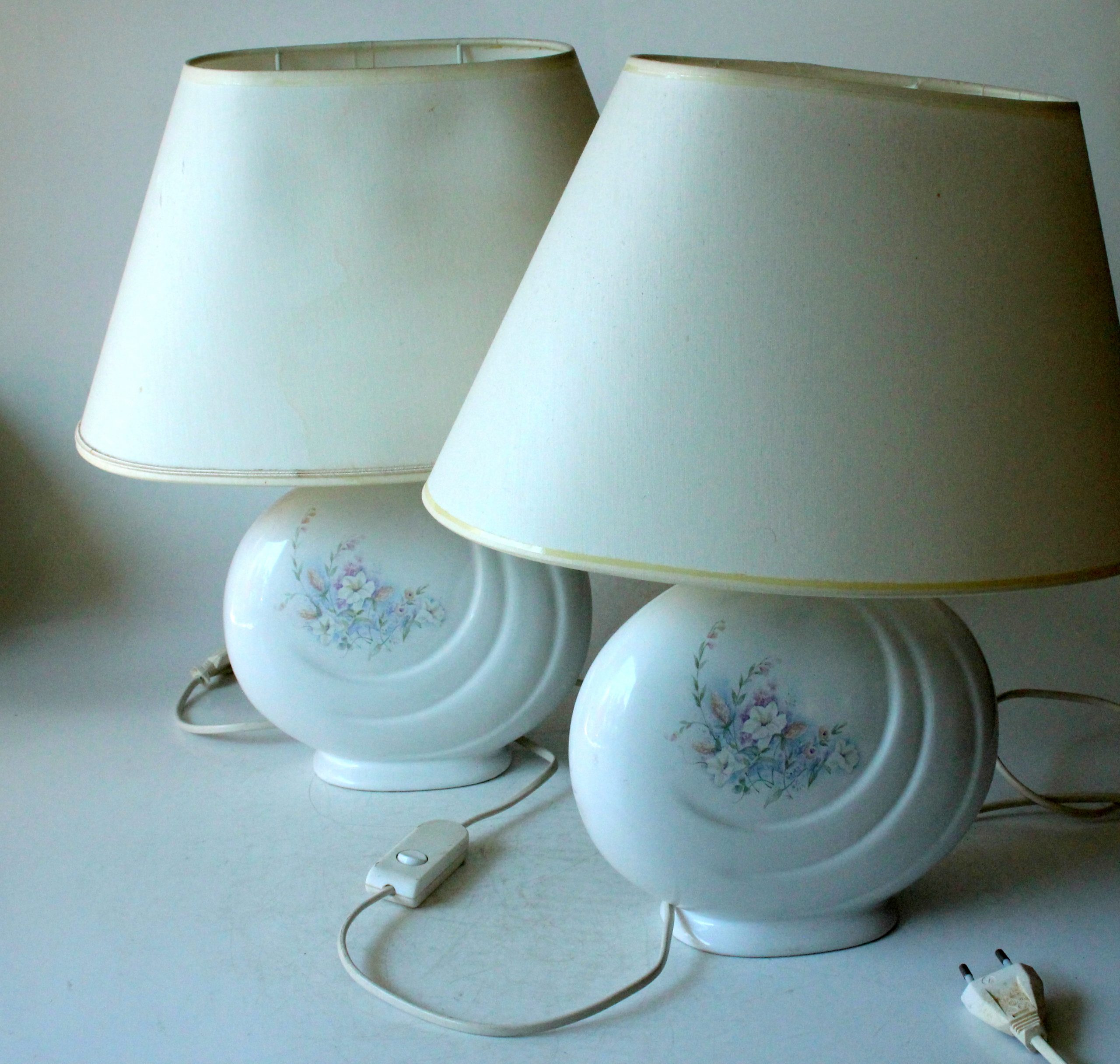 2 Bedside lamps made of white ceramic with floral motifs and with fabric lampshades, vintage from the 1970s