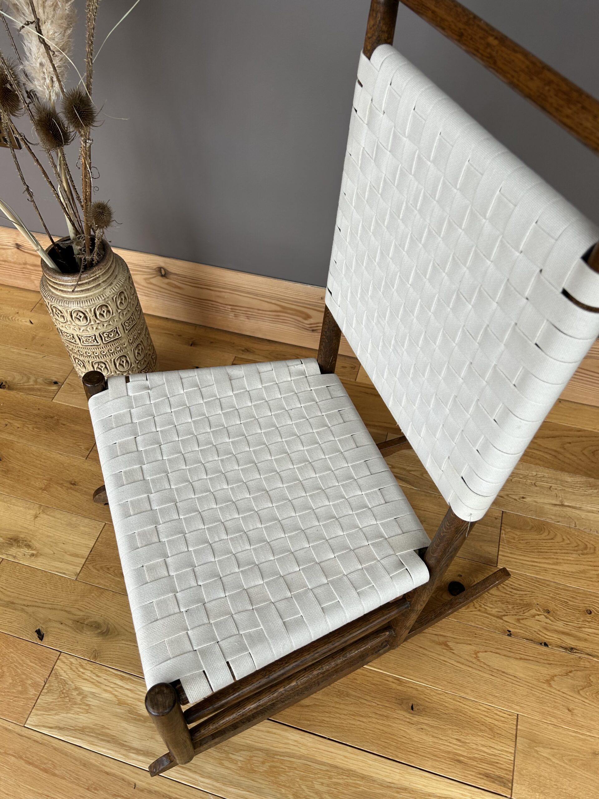 Arts and Crafts Shaker style oak rocking chair with a woven white cotton seat