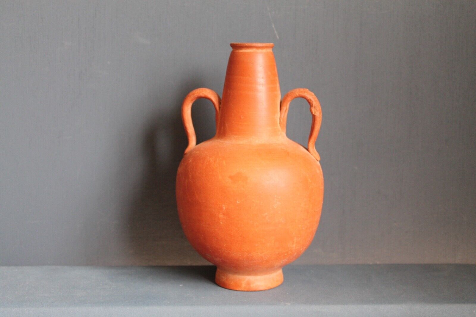 Ancient red-ware Roman amphoriskos. Antique terracotta.