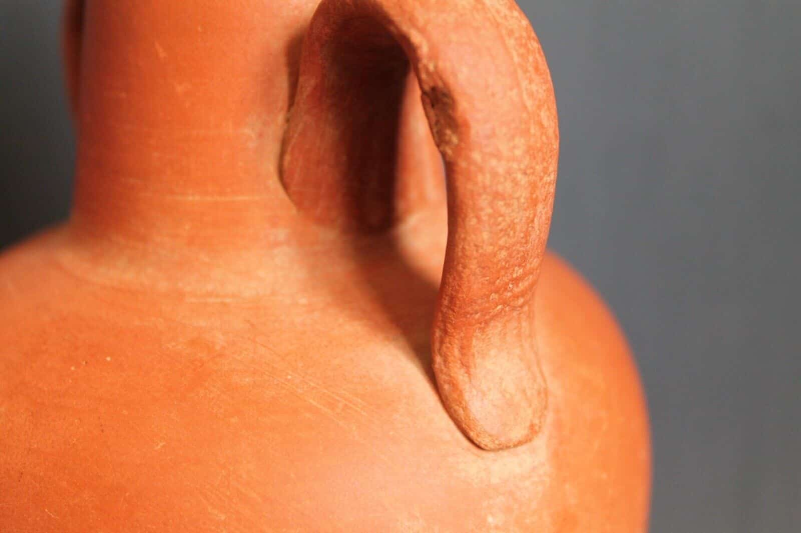Ancient red-ware Roman amphoriskos. Antique terracotta.