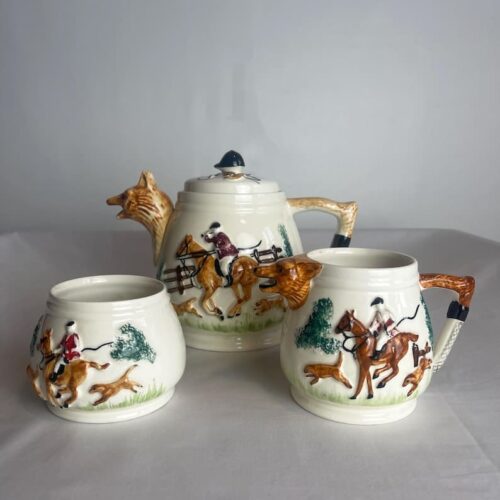 intage Fox & Hounds Tea Set by Paramount Pottery Co circa 1940, all three pieces marked PPC England to the base. All items are in excellent vintage condition, with no cracks, chips, repairs. The three display really well together. Tea pot, sugar bowl and milk jug with hunting scene to the front, saddle &crop to the back. The pot and jug both have a fox’s head for spouts, with the tail as part of the handle. They lid of the pot has a riding hat and 2 foxes with crops. Paramount Pottery Co. were established in Hanley in 1946 by Charles Griffith Bowers, and went into making item like the one (known as "cottage ware"). They were quickly acquired by a larger company called Keele Street Pottery, who had been founded in 1915 by a group of 4 dynamic and well known Staffordshire ceramics experts. Between 1947 and 1949 they bought Paramount, Winterton Pottery, Thomas Cone, Alma Works, Collingwood Bone China, Conway Pottery, Piccadilly Pottery, and Lawton Pottery. This firm carried on growing through the post war period and in 1950 they changed their name to "Staffordshire Potteries Ltd". Priced for the set.