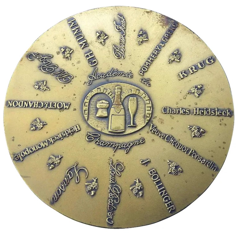 A bronze Advertiser for Champagne Academy Commemorative Disc Paperweight C.1982