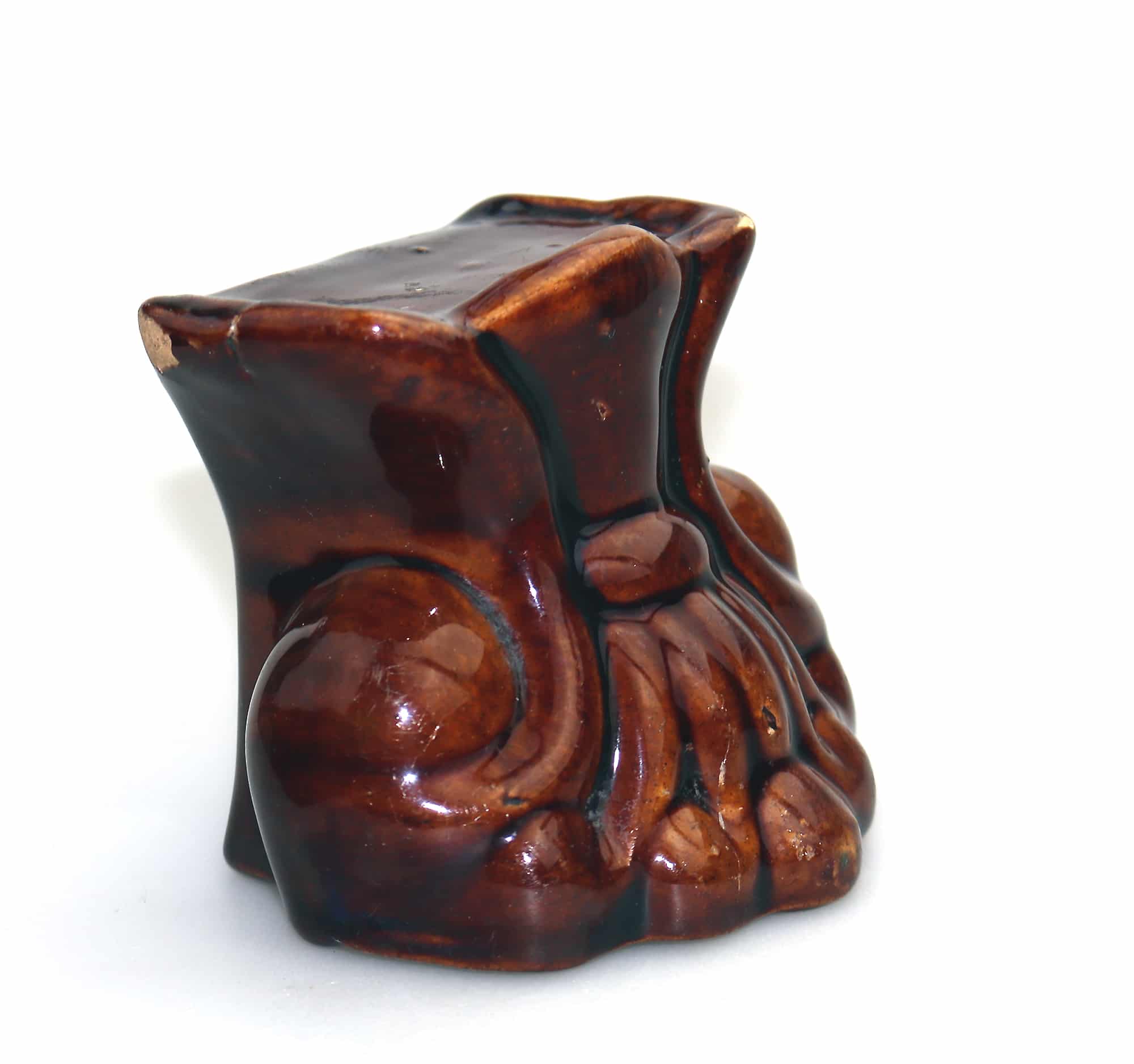 An antique Georgian Rockingham treacle pottery lion paw furniture support C.1825