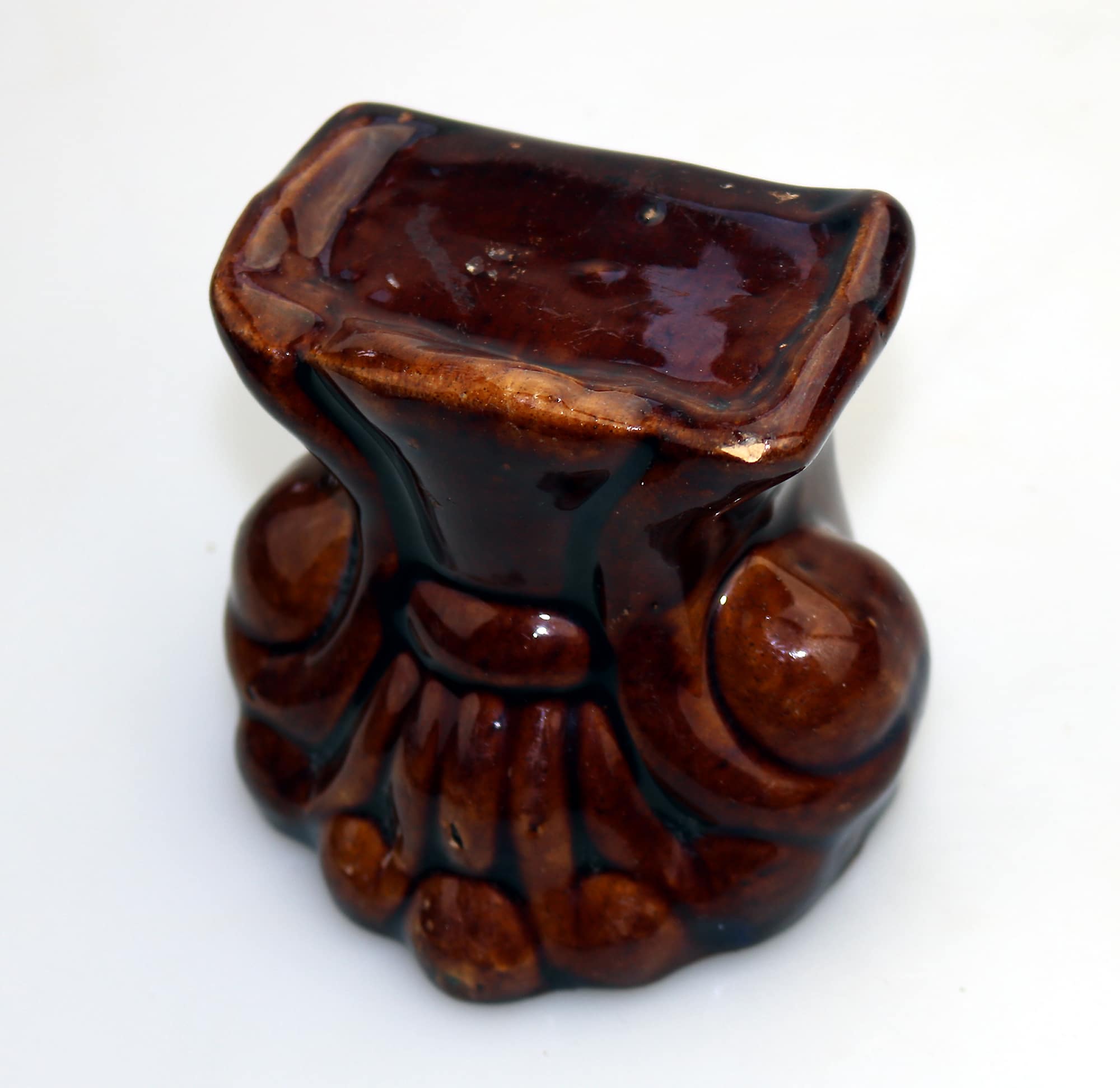 An antique Georgian Rockingham treacle pottery lion paw furniture support C.1825