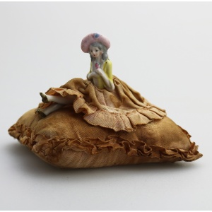 A good antique hand-painted porcelain half doll with legs on cushion C.early 20thC