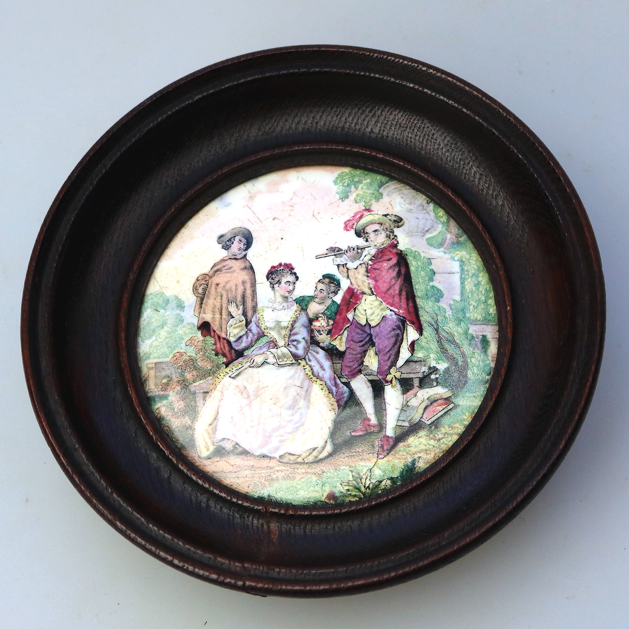 An antique framed English Prattware pottery Pot Lid The Flute Player C.19thC