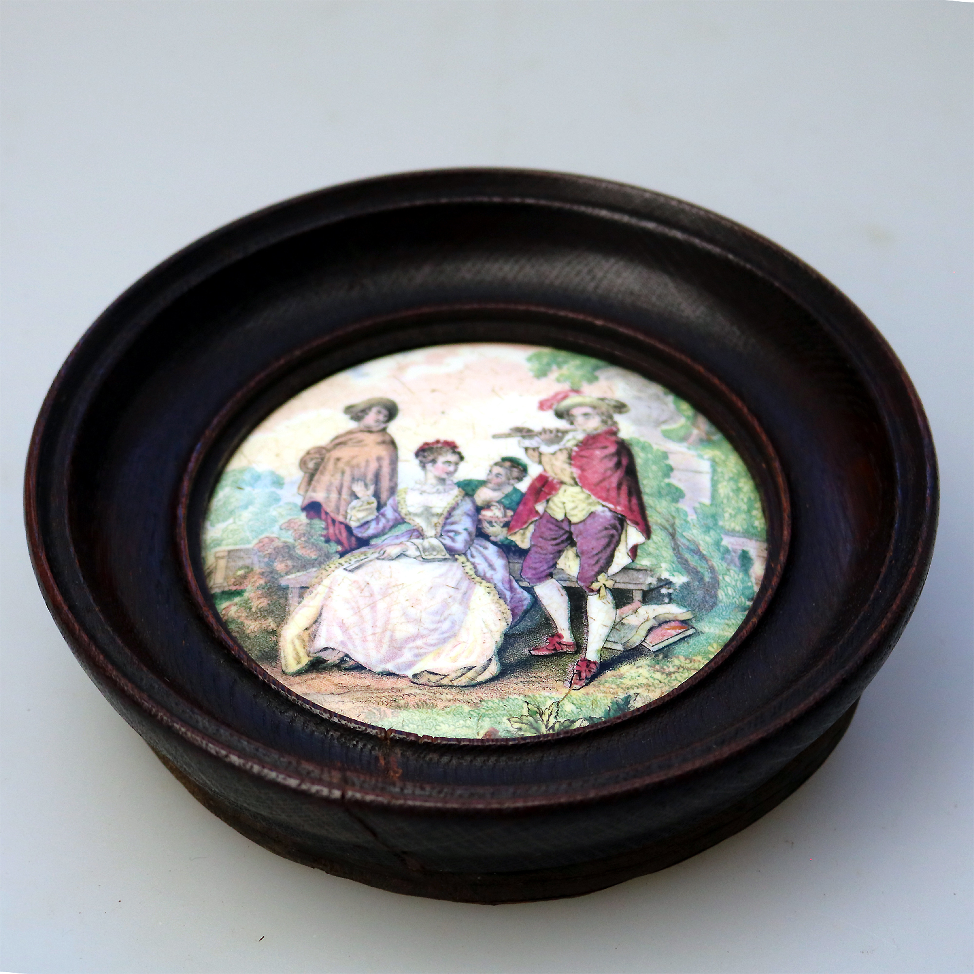 An antique framed English Prattware pottery Pot Lid The Flute Player C.19thC