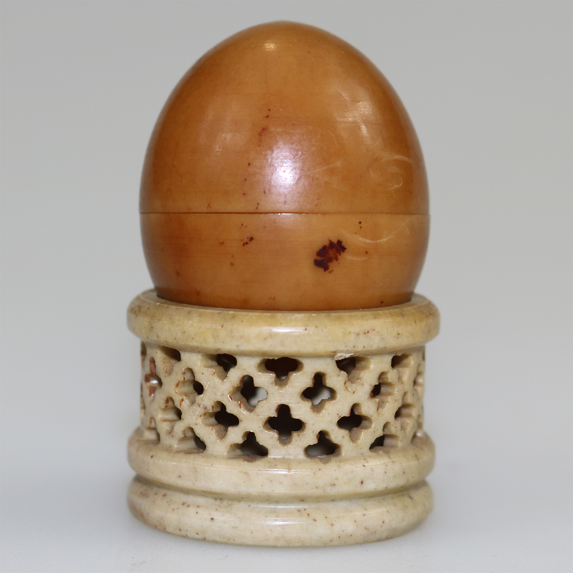 An unusual antique oriental threaded carved nut box on hardstone stand C.1900