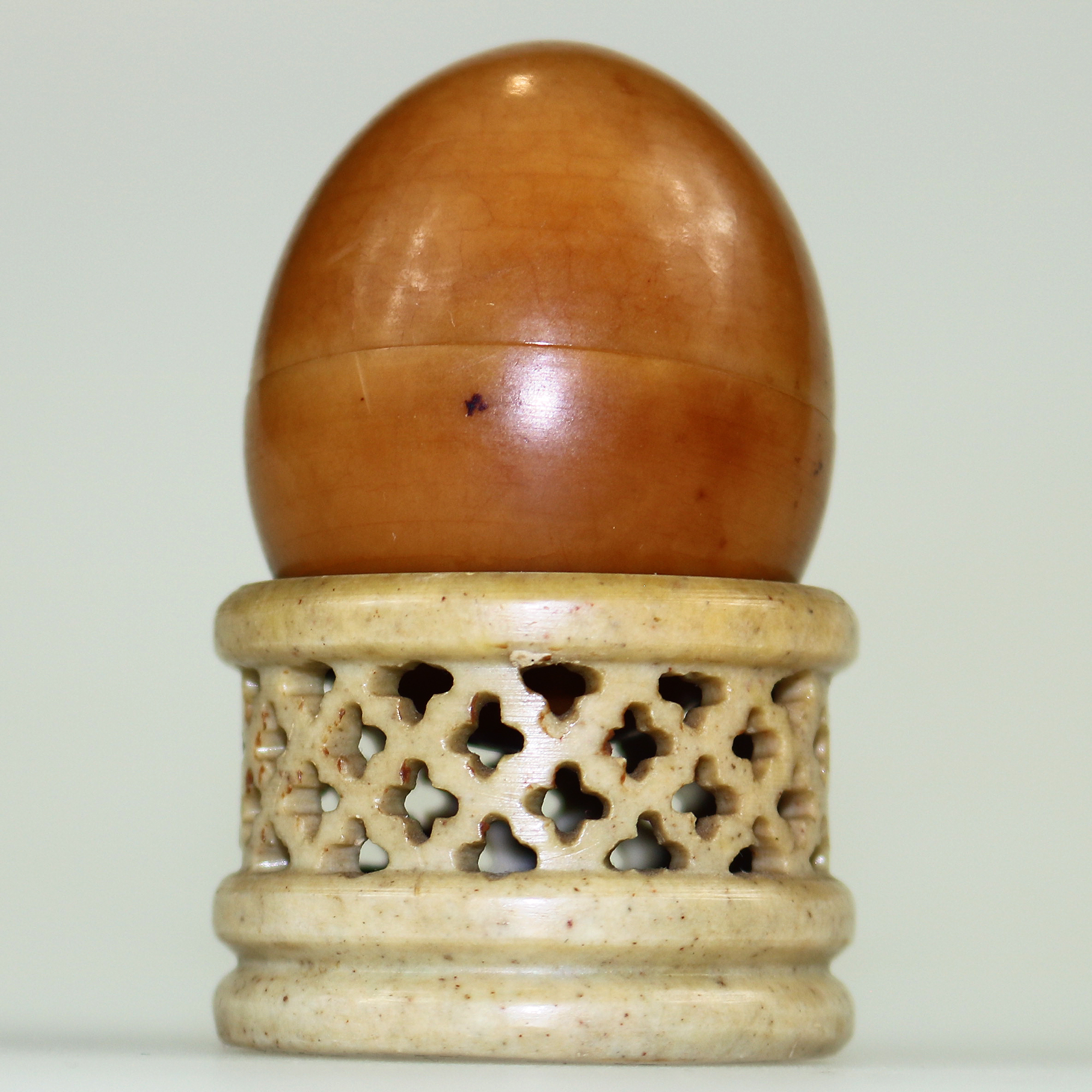 An unusual antique oriental threaded carved nut box on hardstone stand C.1900