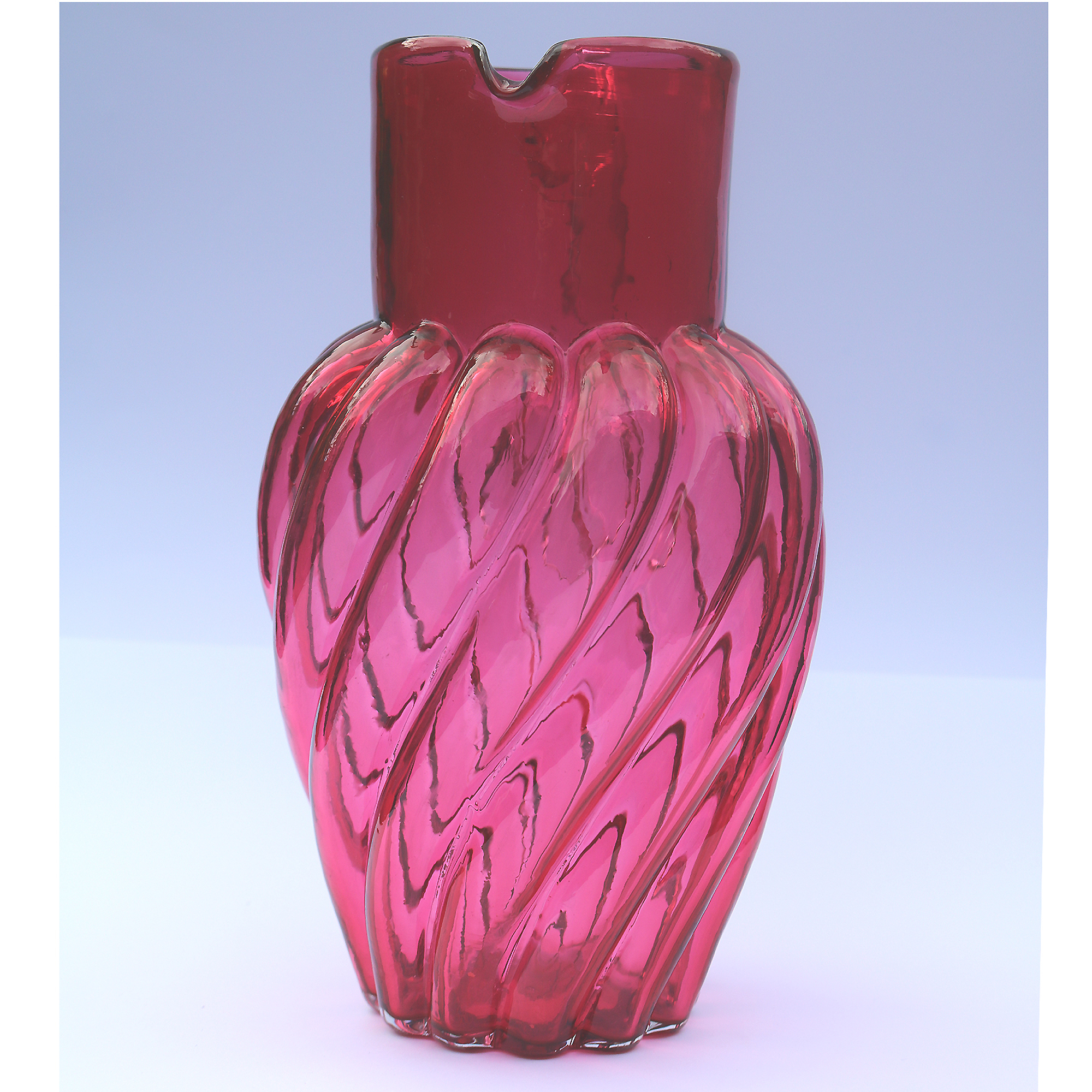 An extraordinary and large antique wrythen pattern cranberry glass Jug C.1900