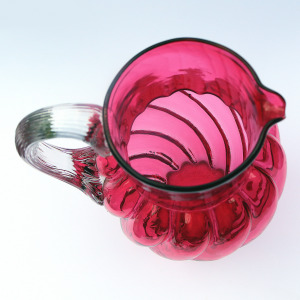 An extraordinary and large antique wrythen pattern cranberry glass Jug C.1900
