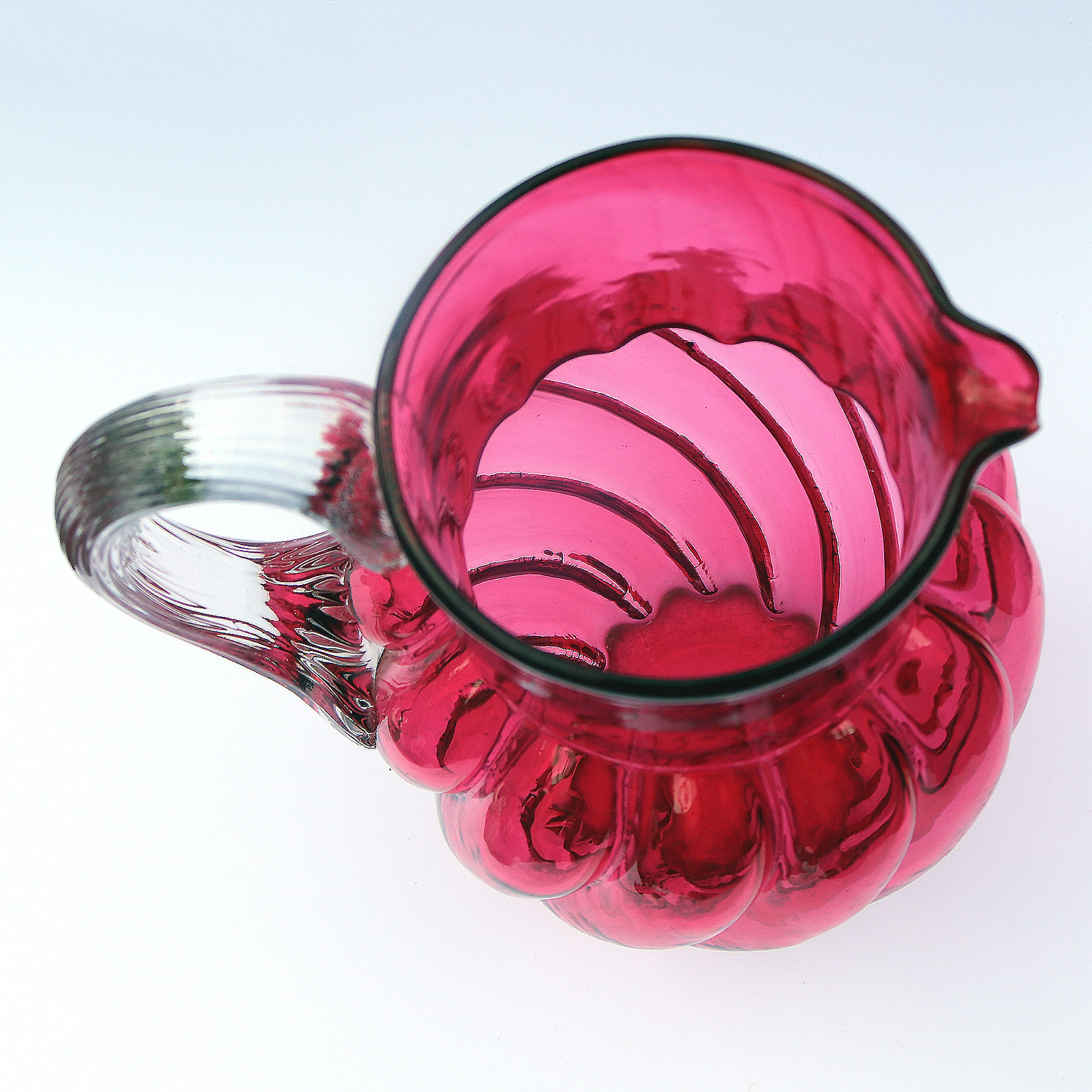 An extraordinary and large antique wrythen pattern cranberry glass Jug C.1900