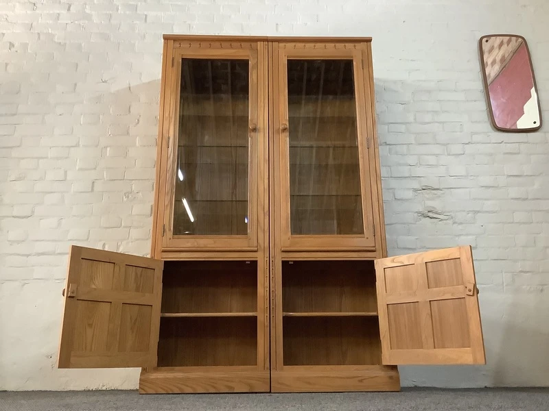 Pair Of Ercol Mural Glazed Cabinets In Light Finish.